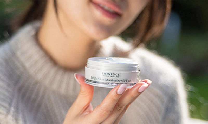 Woman holding Éminence Bright Skin Moisturizer SPF 40