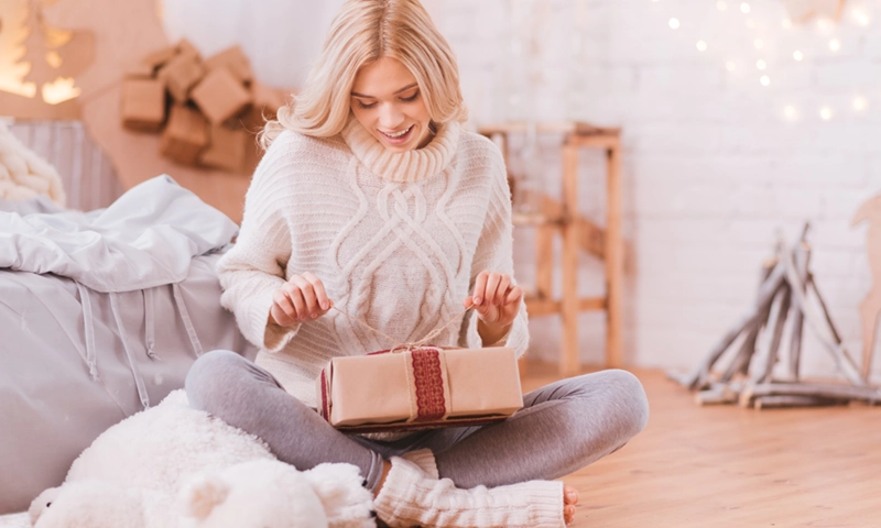 happy woman opening up sustainable gift