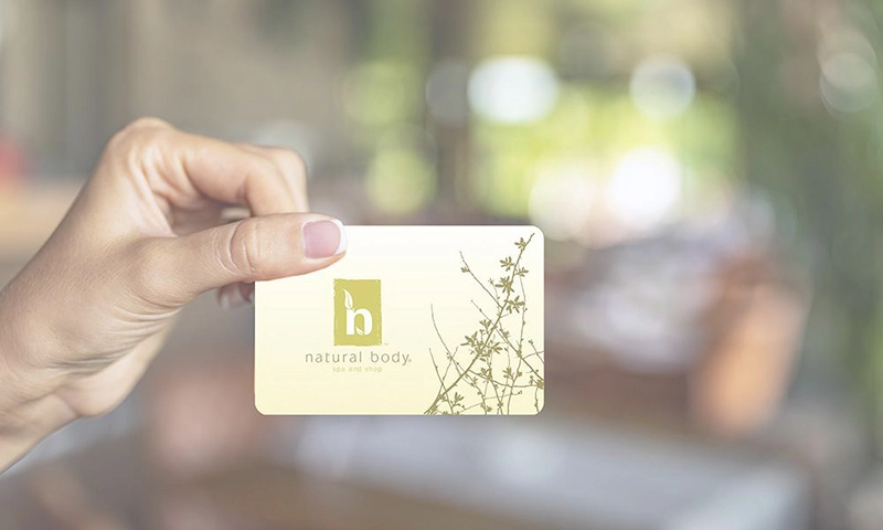 Woman's hand holding Natural Body gift card
