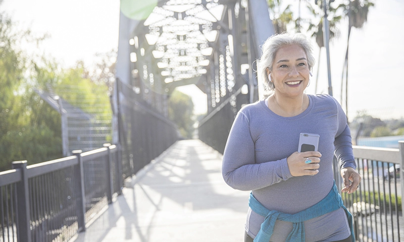 A mature woman jogging on a trail