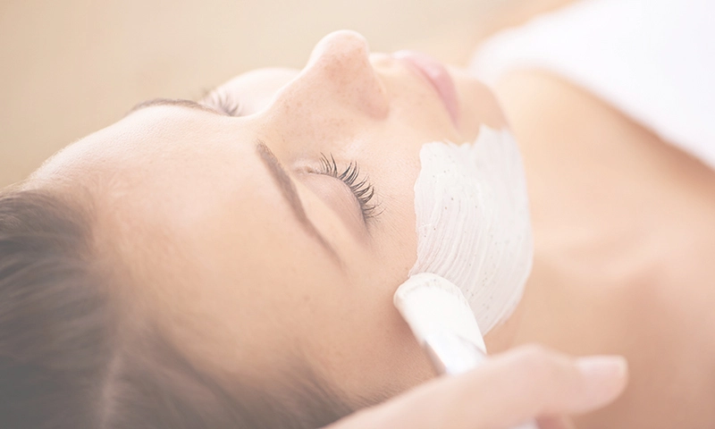 facial mask being brushed onto a woman