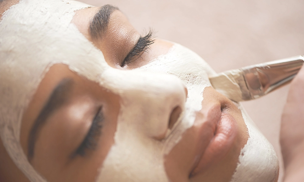 woman having a mask brushed onto her face