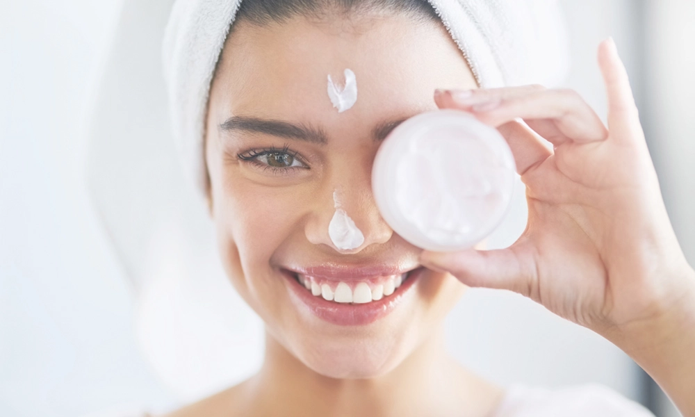 young woman holding face cream