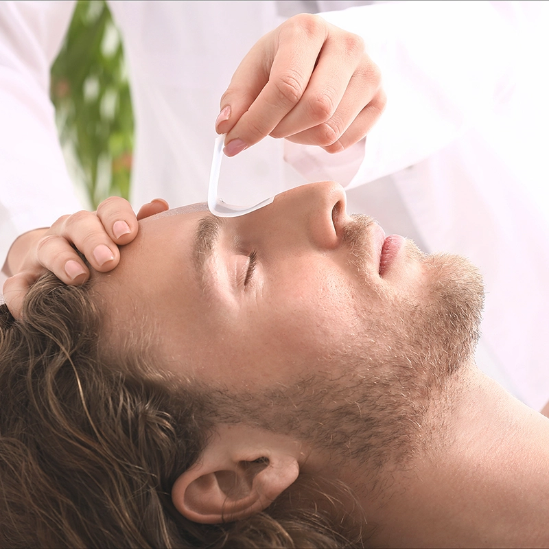 man getting eyebrows waxed at day spa