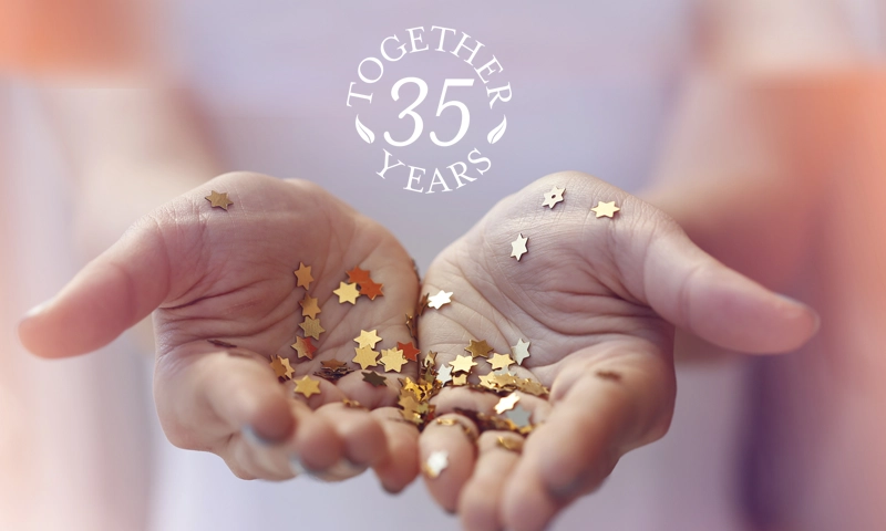 hands holding confetti starts with Natural Body Together 35 years logo