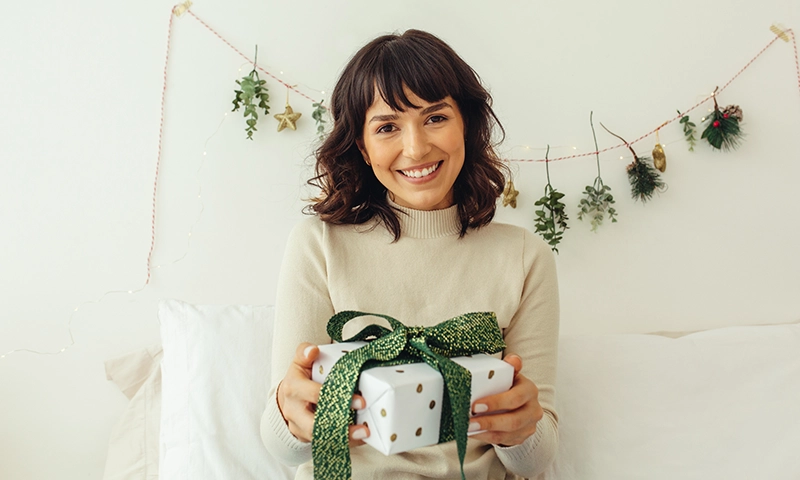 beautiful woman holding a fall leave and wearing a red hat